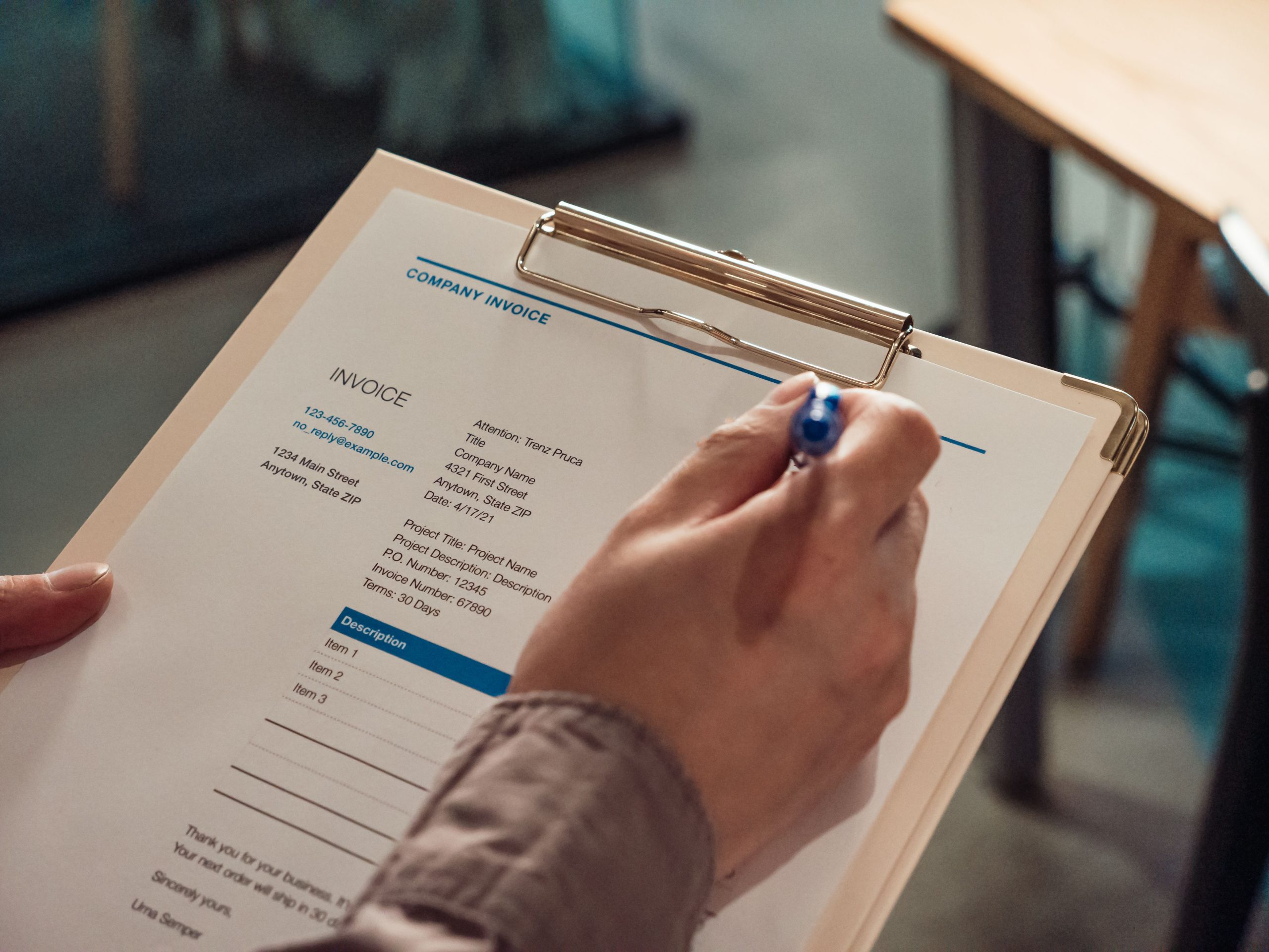 Main tenant une facture sur presse-papiers