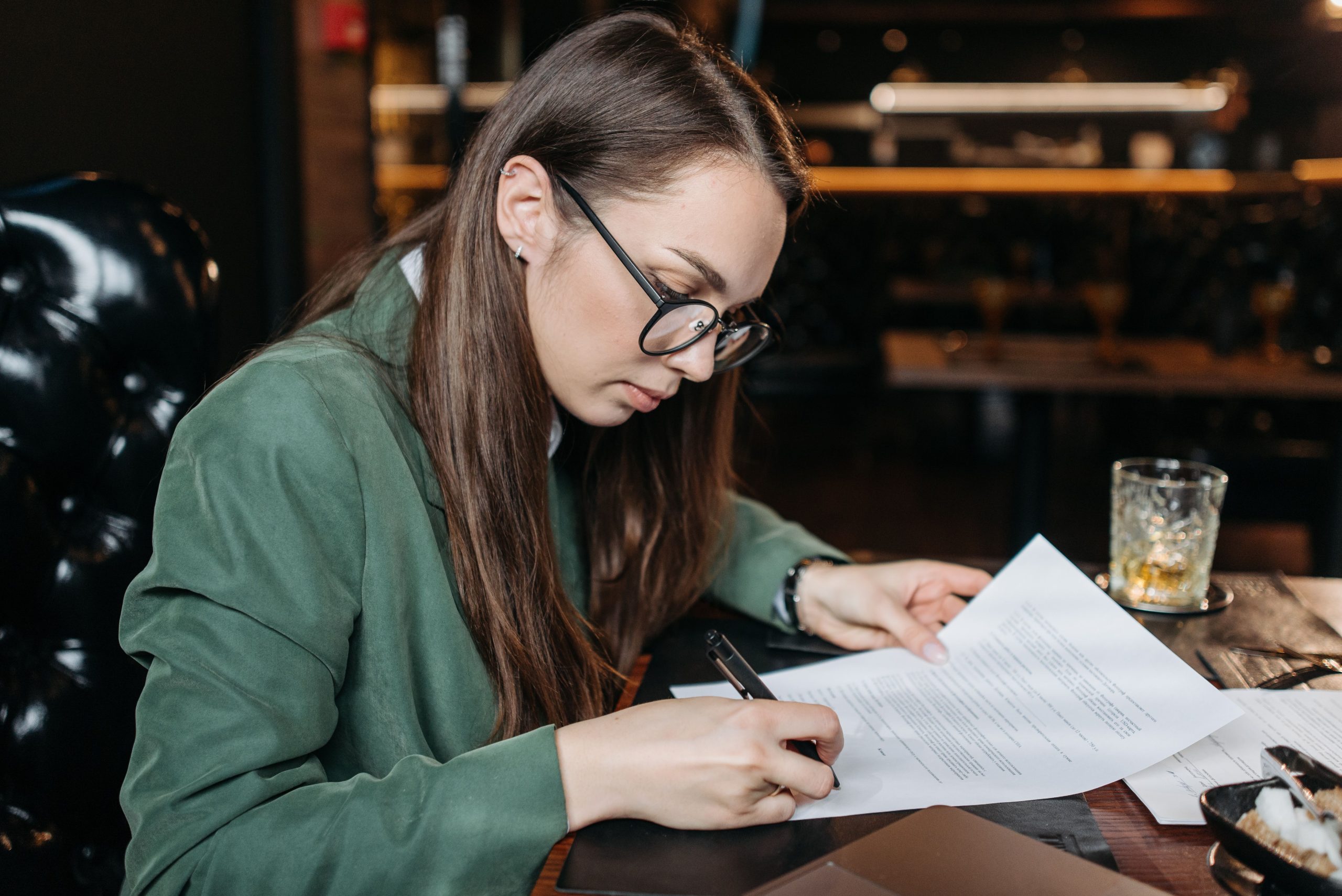Femme concentrée signant des documents importants