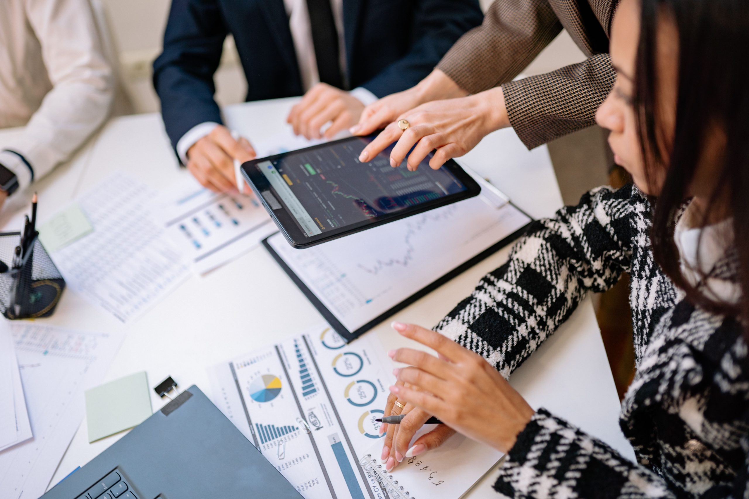 Professionnels analysant des données sur tablette en réunion