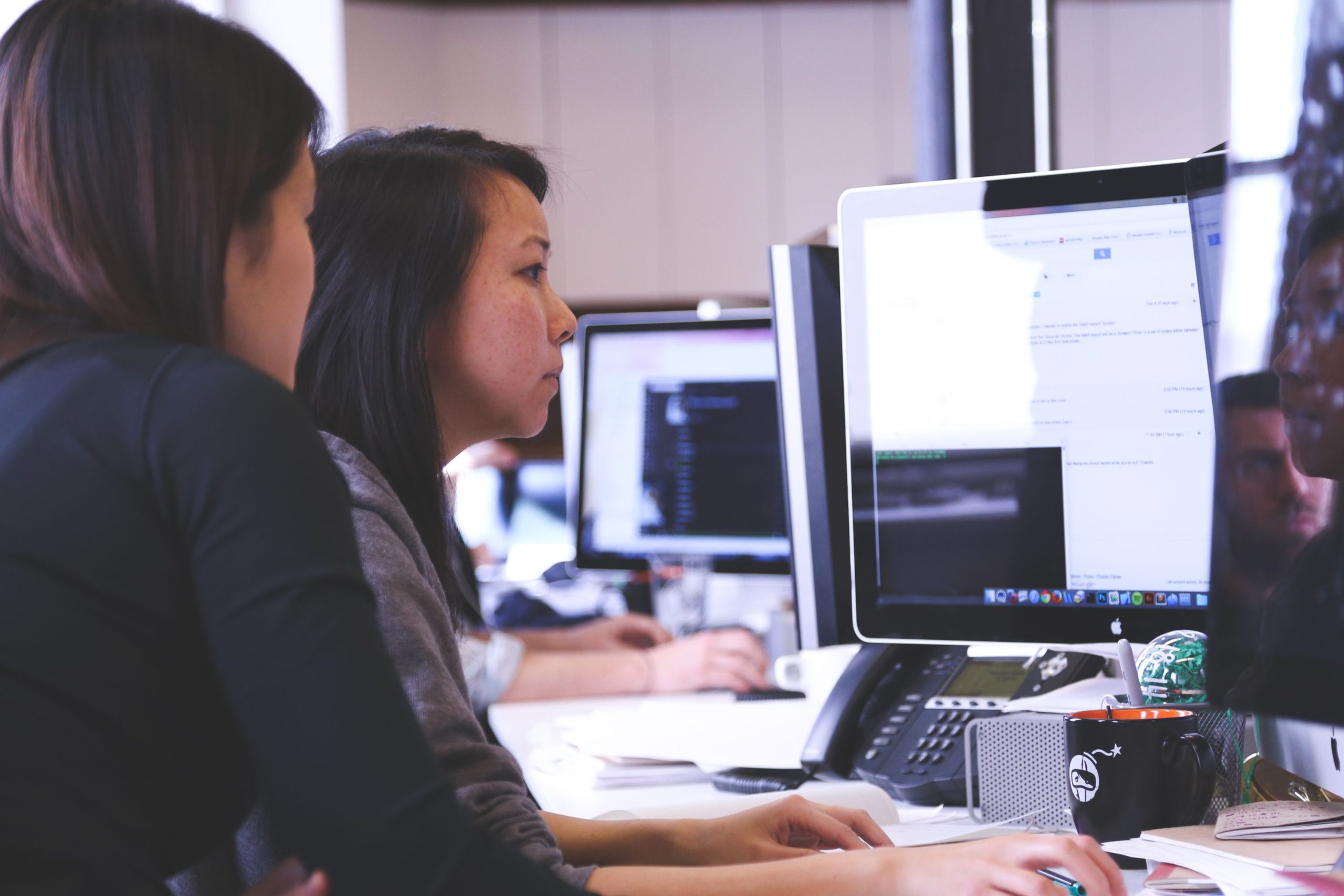 Deux femmes collaborent sur du code informatique