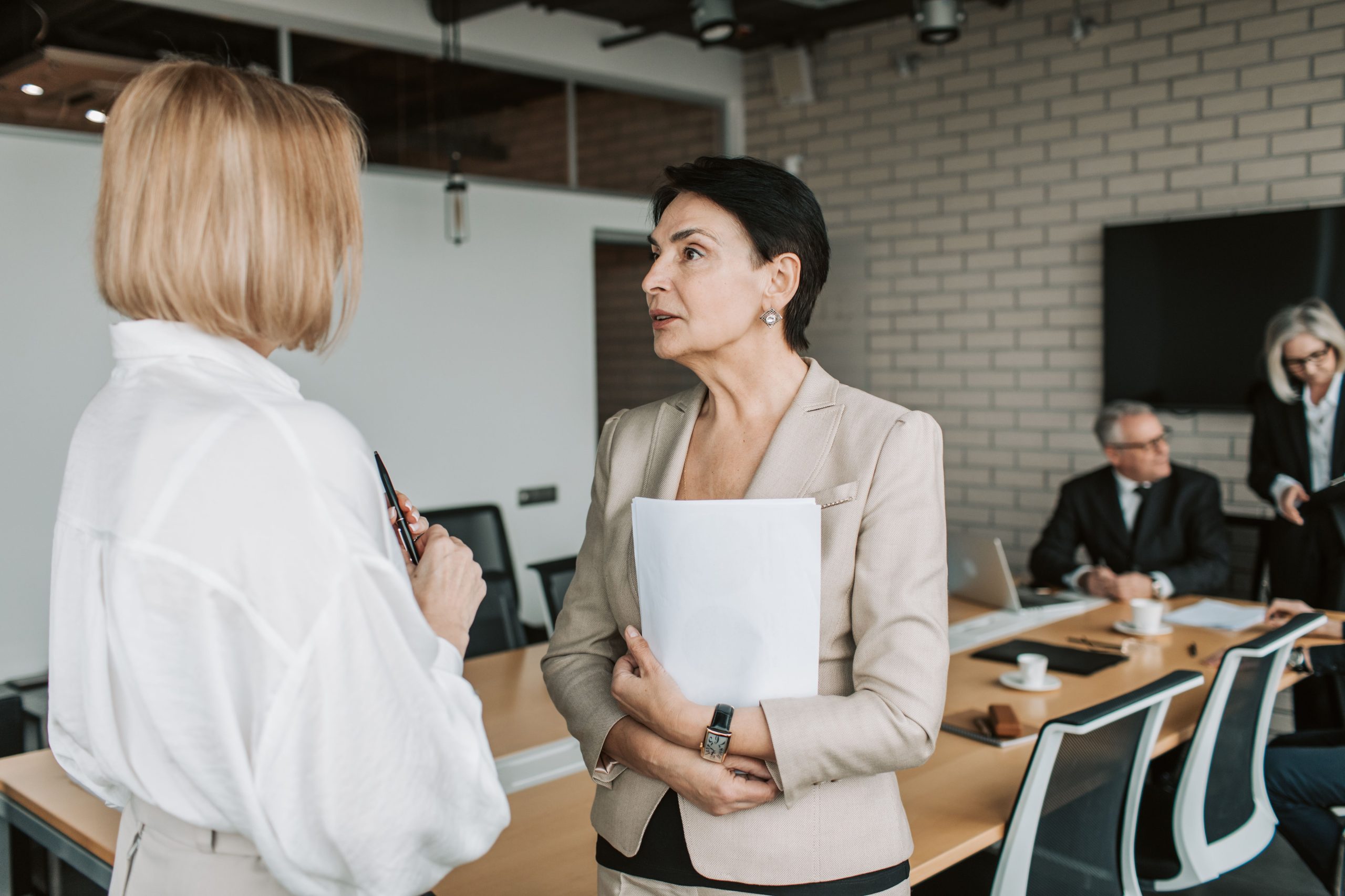 Deux femmes d'affaires conversent en réunion