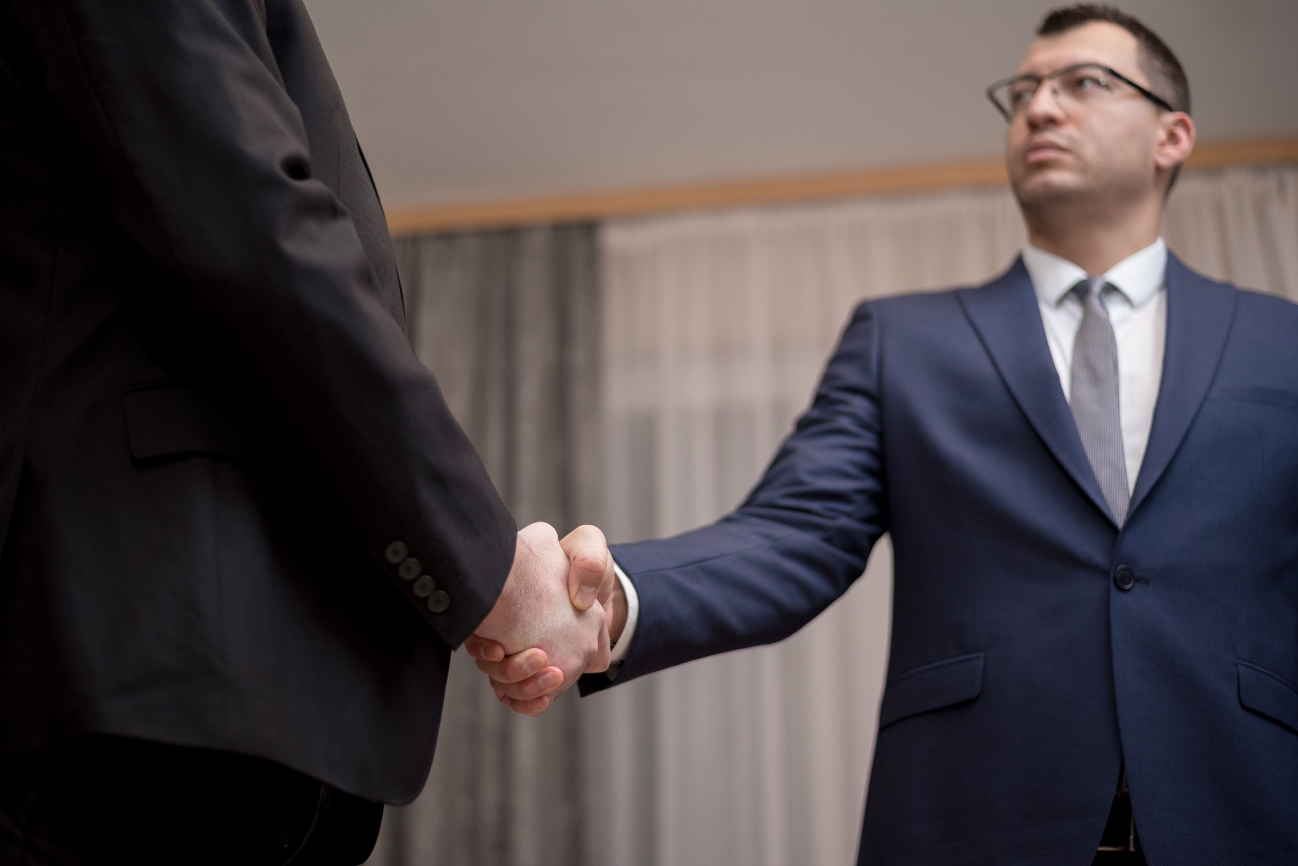 Deux hommes d'affaires en costume se serrent la main