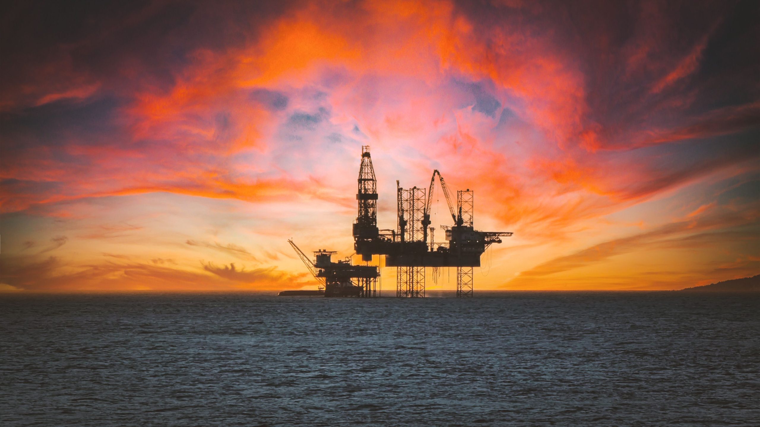 Plateforme pétrolière en silhouette au coucher de soleil