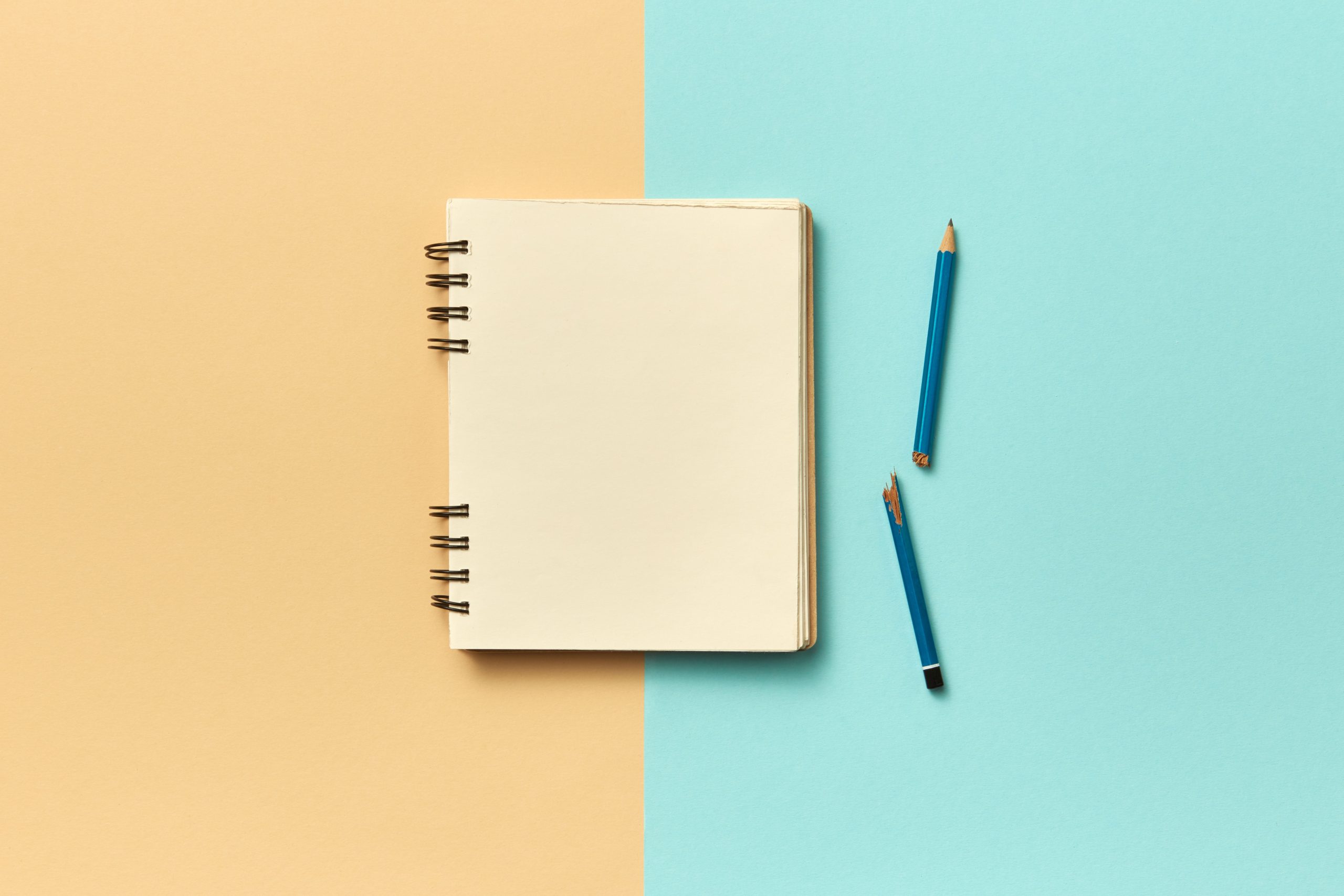 Carnet et crayons sur fond pastel minimaliste