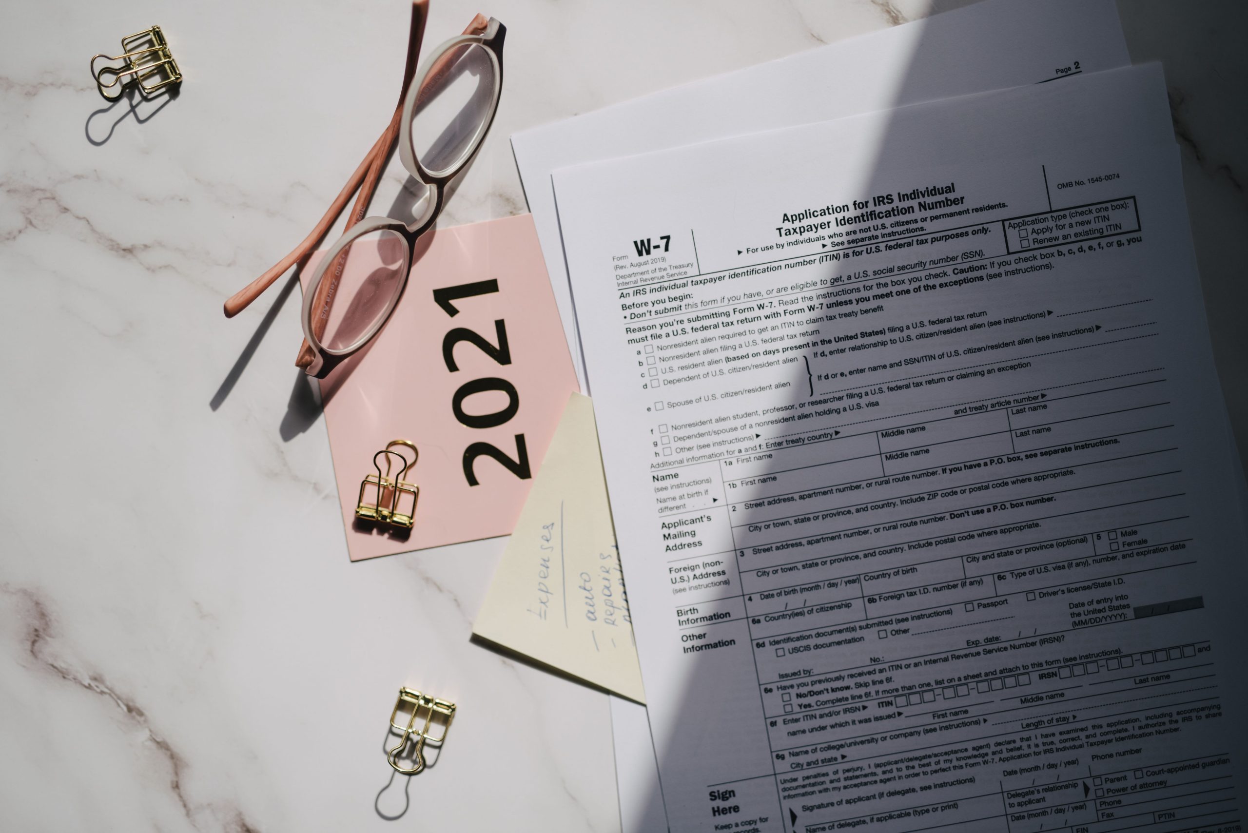Documents fiscaux avec lunettes et notes sur marbre