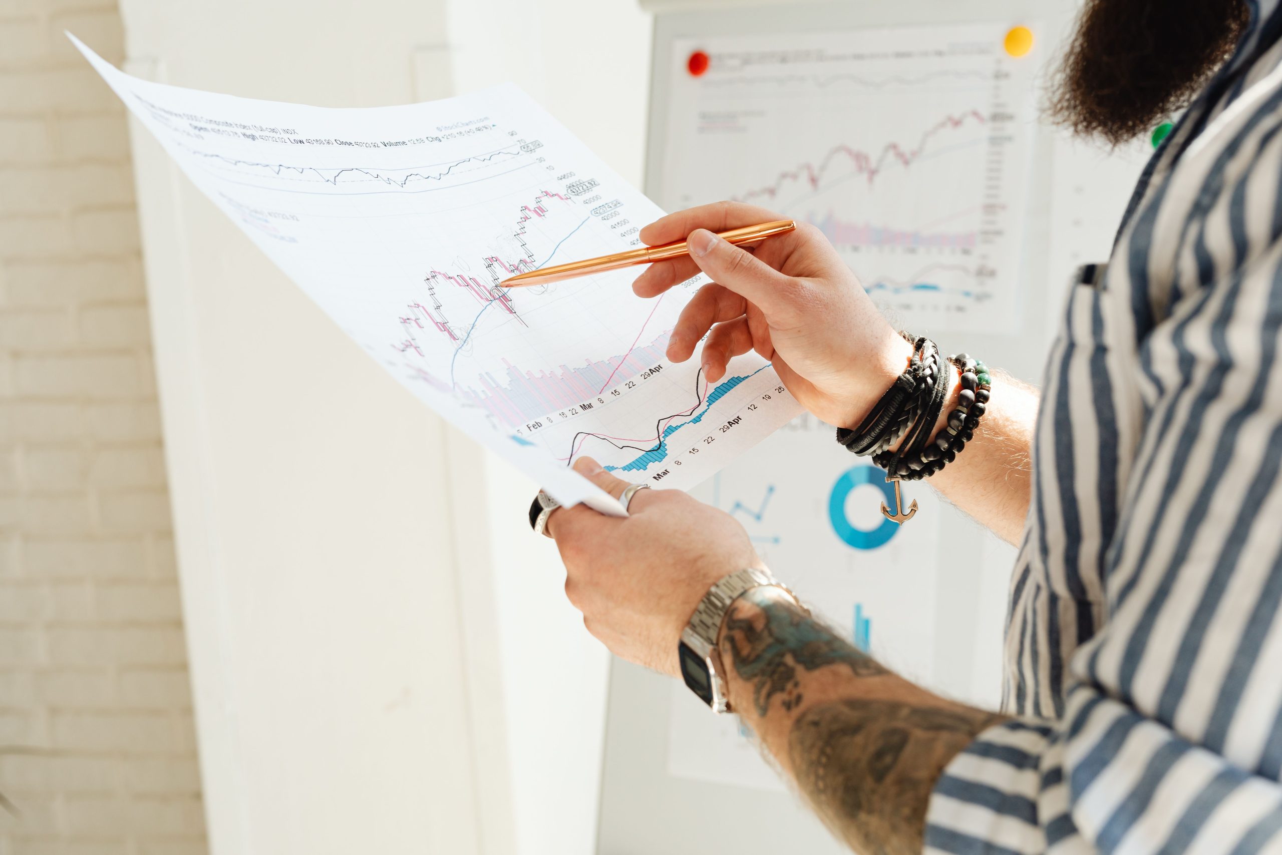 Homme etudiant graphiques boursiers avec rapport papier