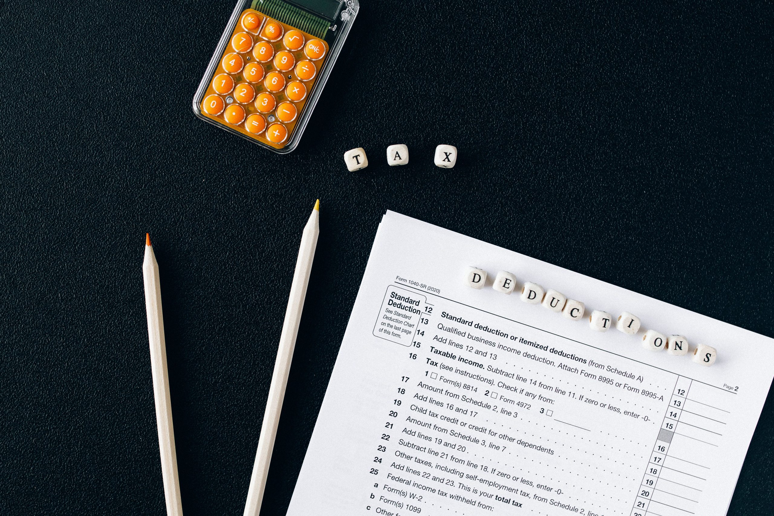 Formulaire fiscal, crayons et calculatrice sur fond noir