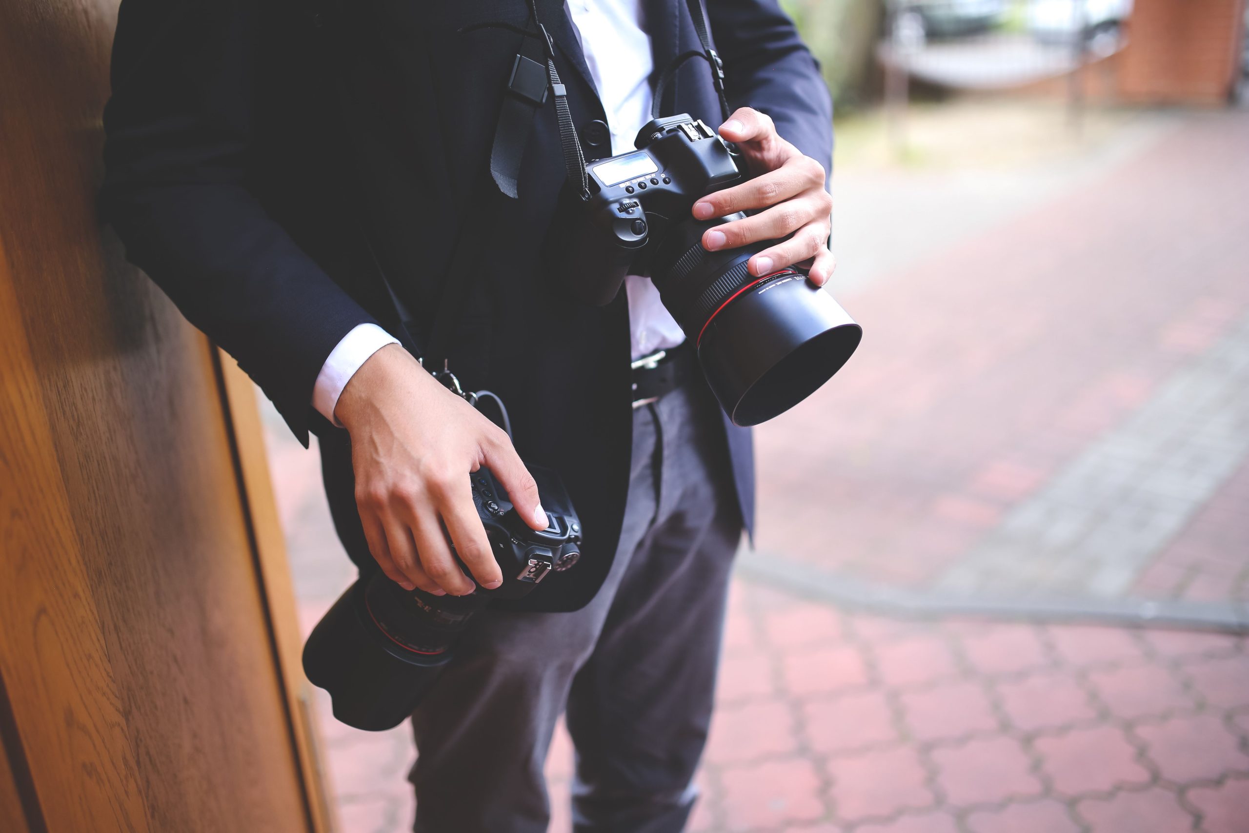Photographe tenant deux cameras DSLR dehors