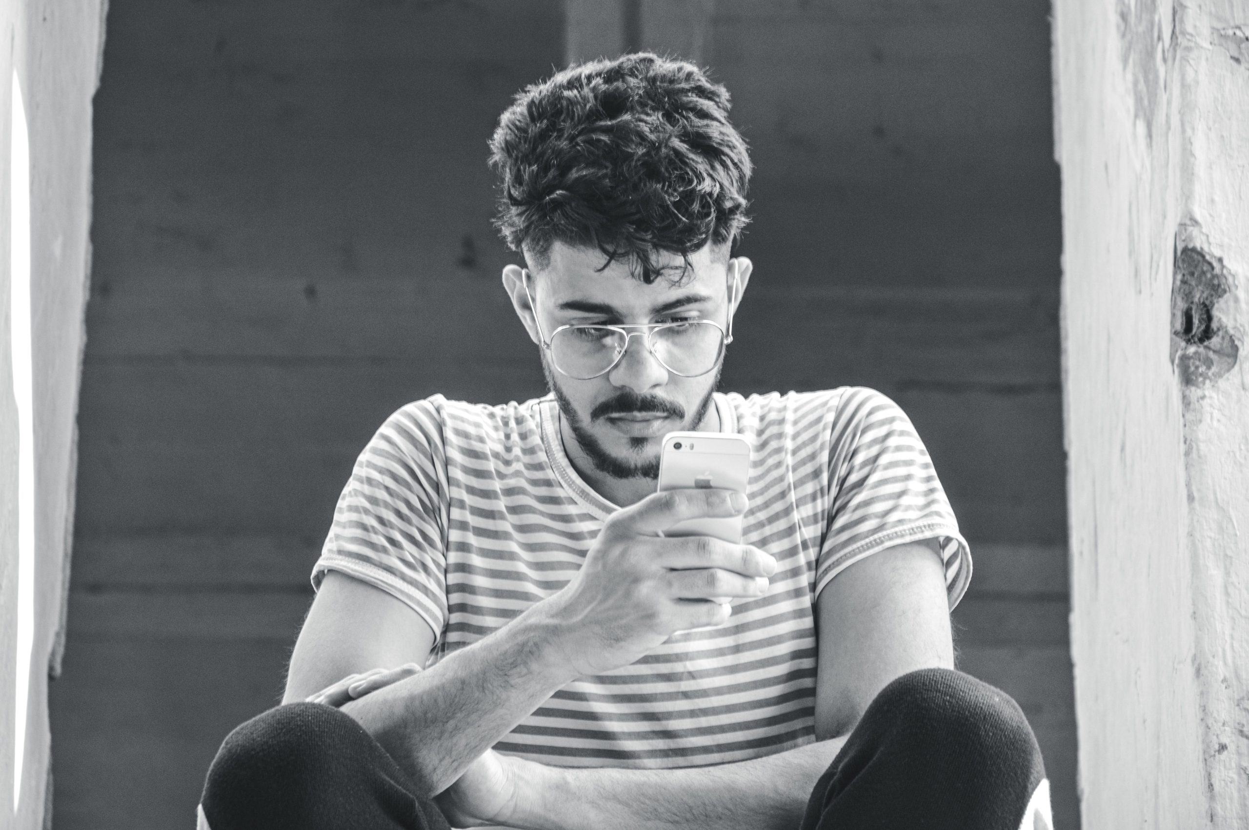 Homme lunettes utilise smartphone portrait monochrome