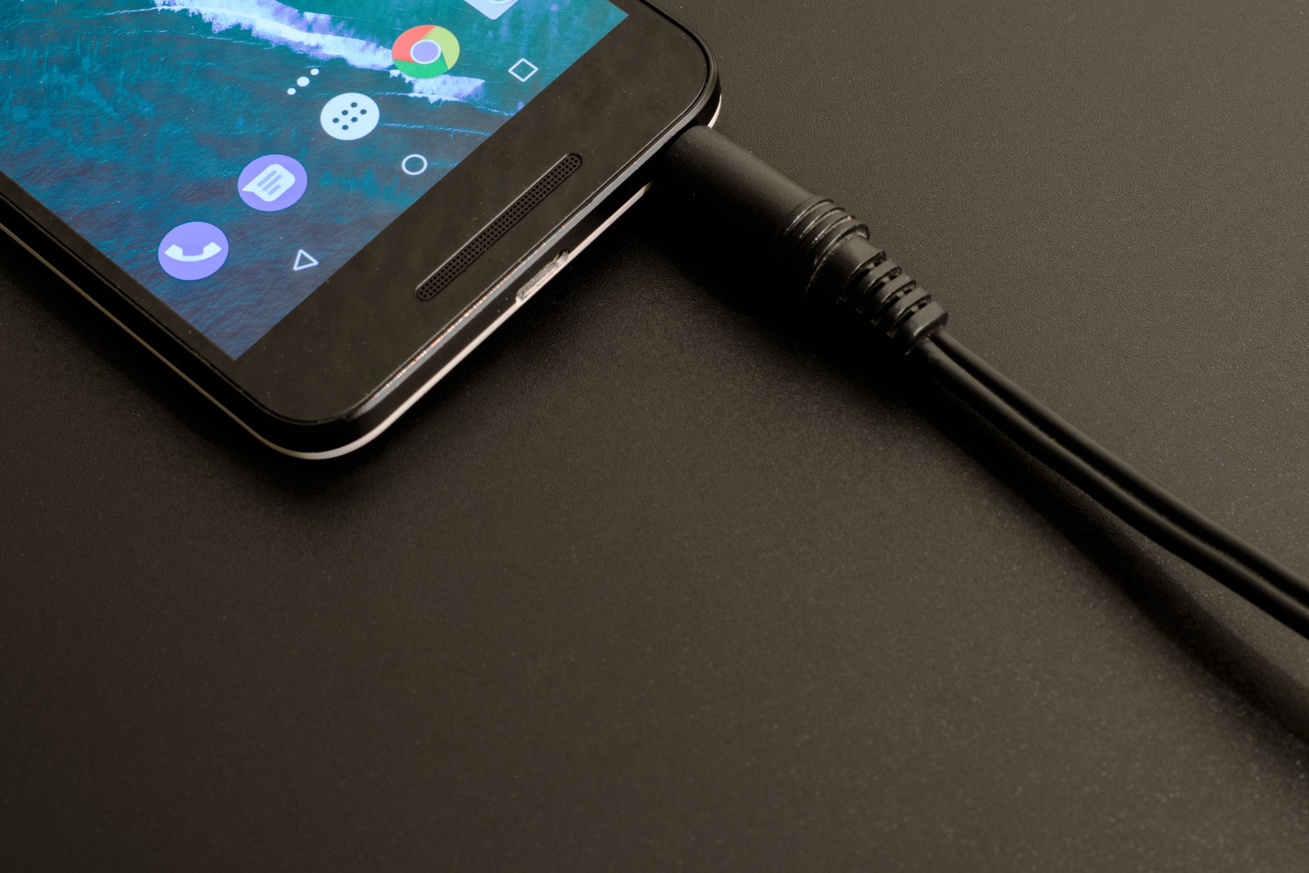 Smartphone en charge sur fond sombre moderne