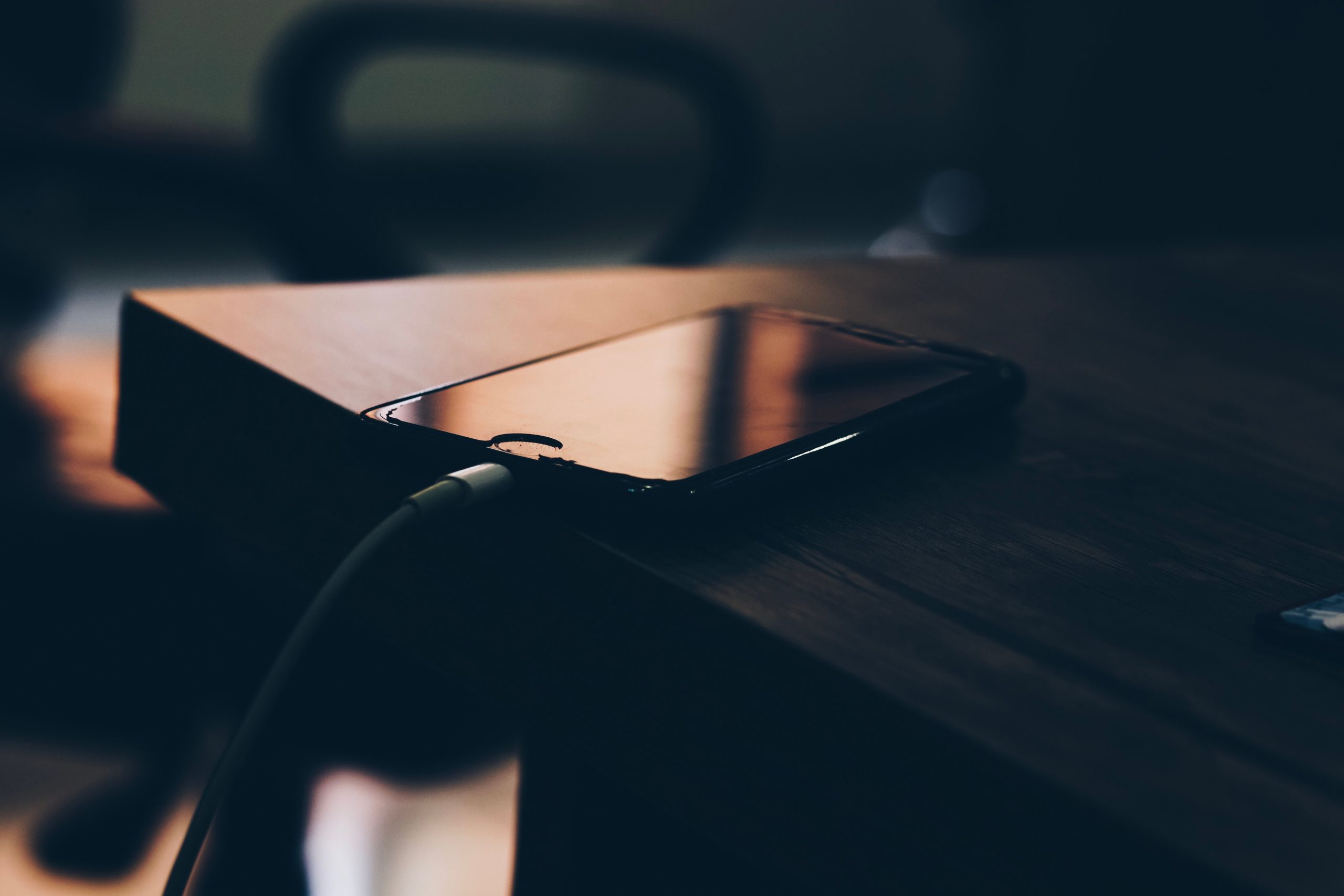 Smartphone branché sur chargeur en bois