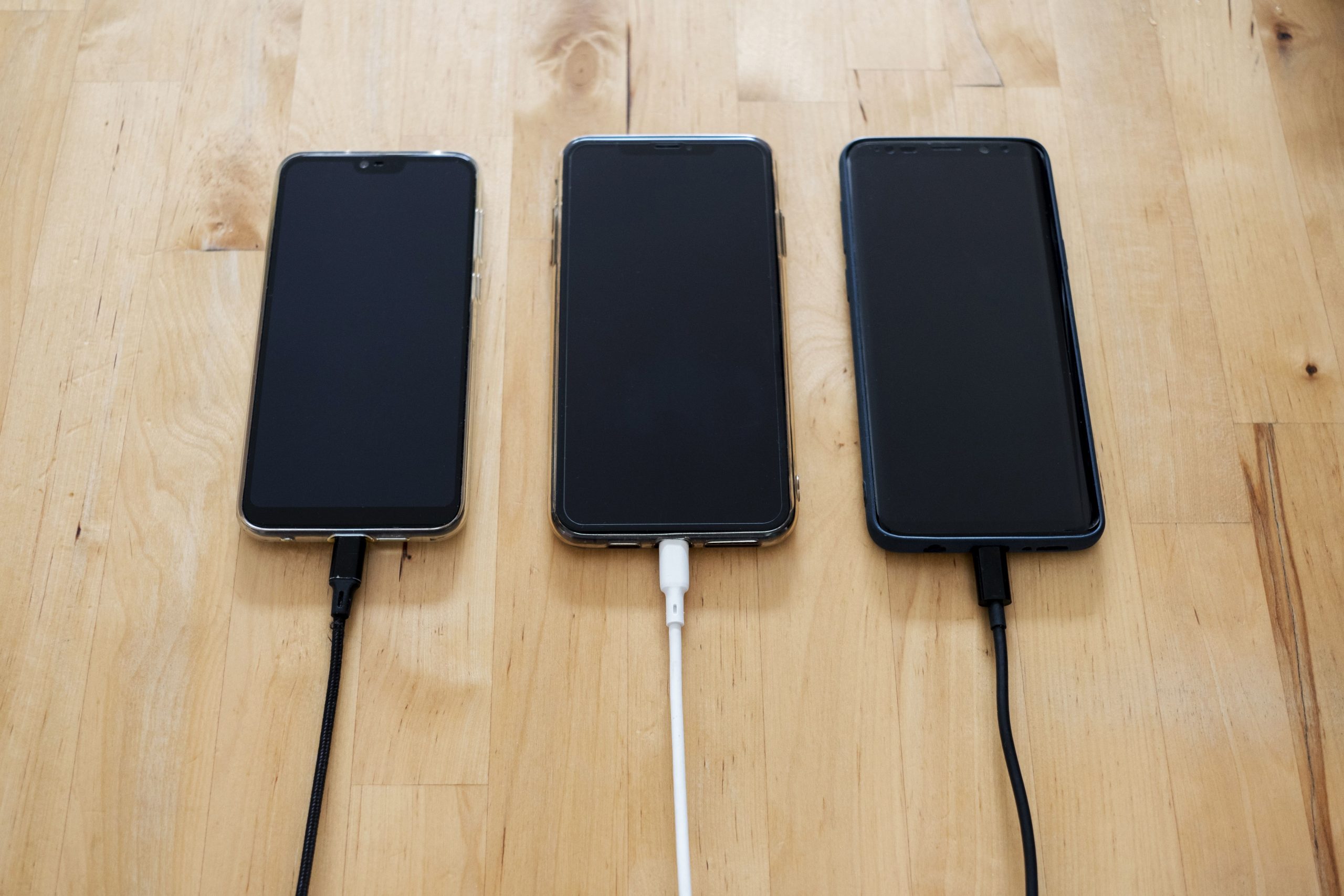 Trois téléphones connectés à des chargeurs