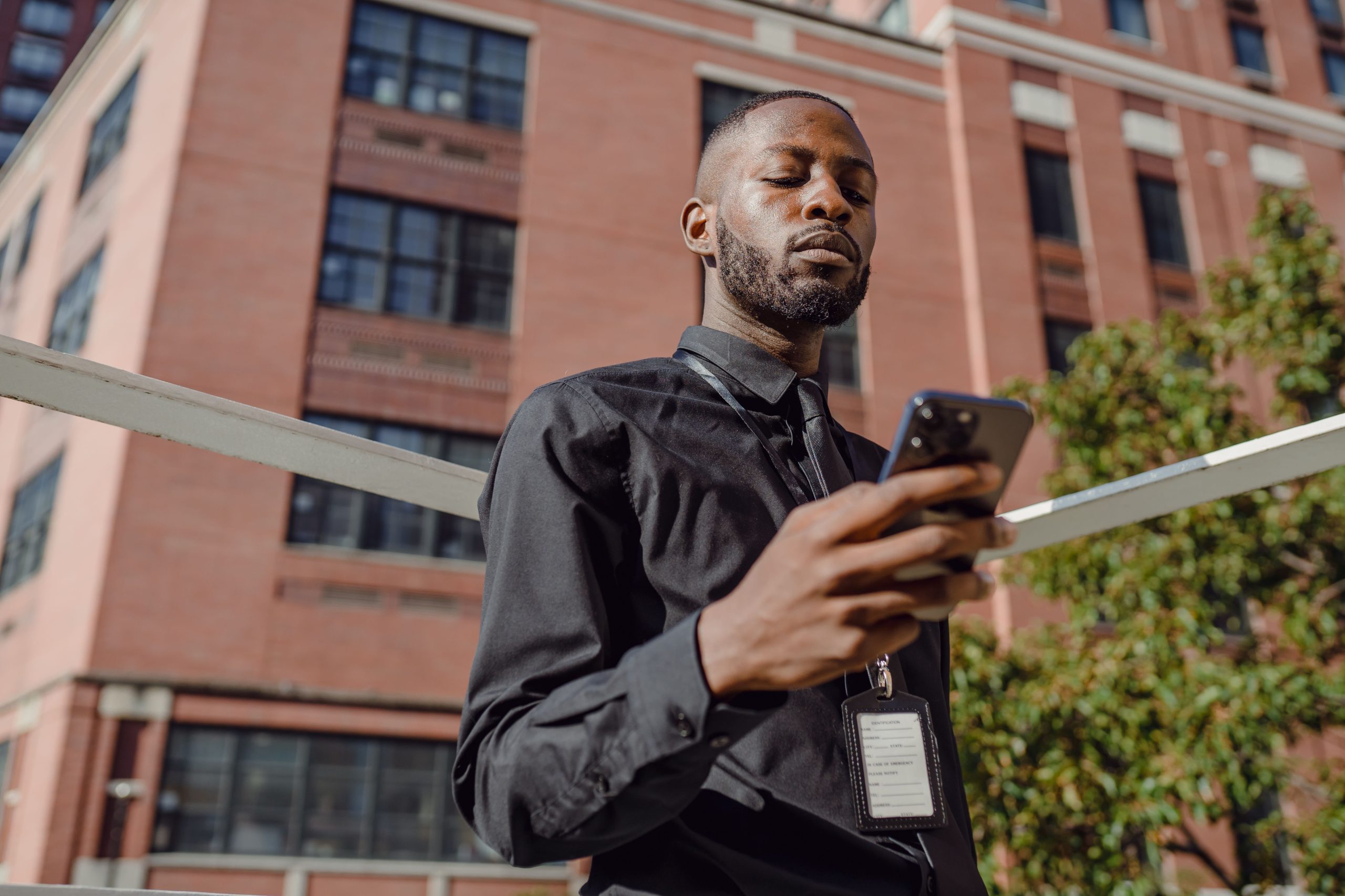 Homme affaires utilisant téléphone devant immeuble