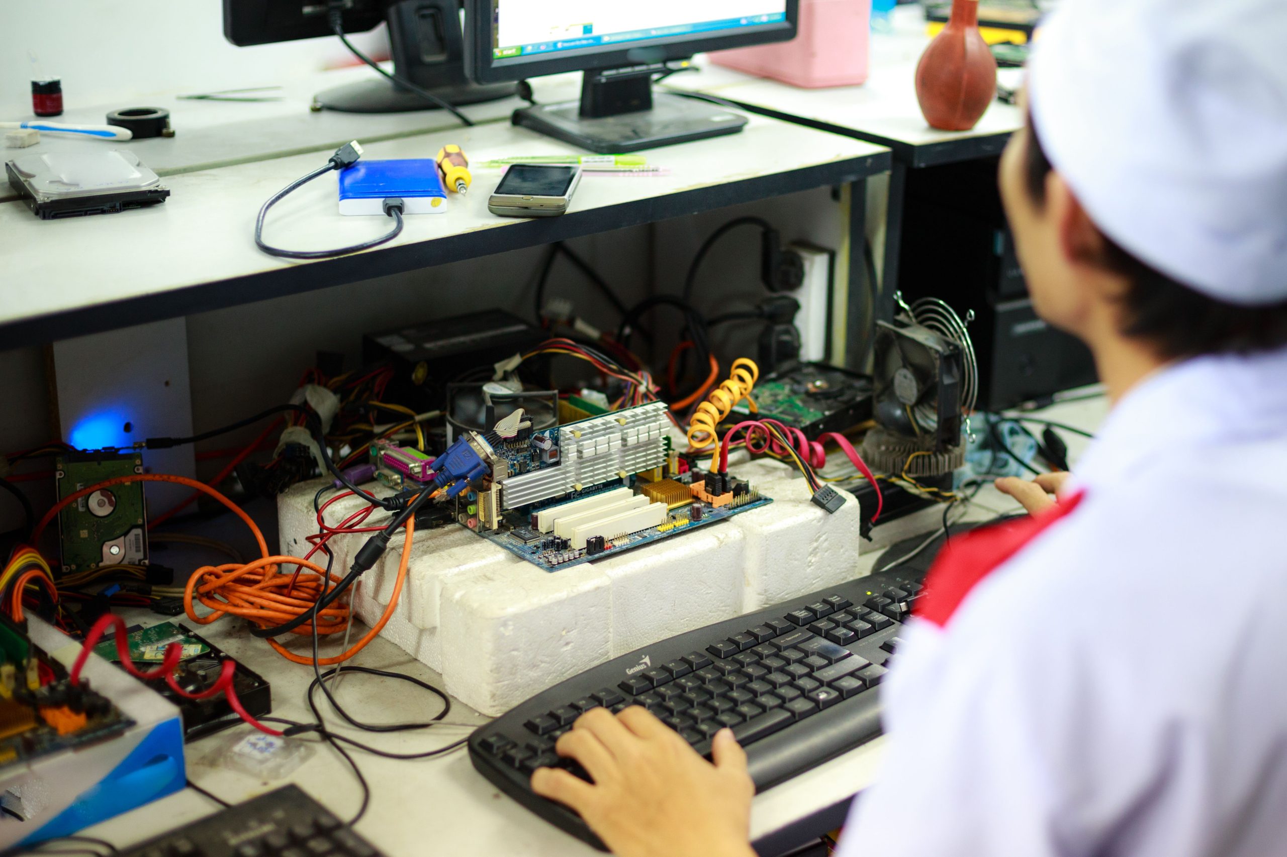 Technicien en uniforme travaillant sur composants informatiques