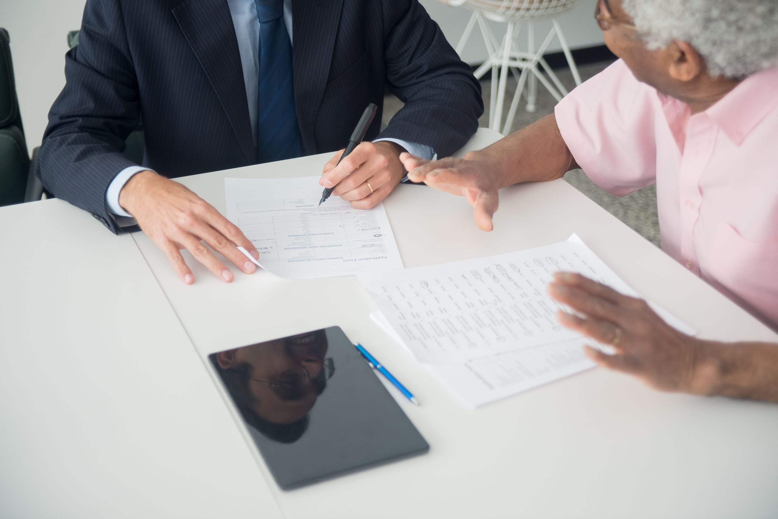 Réunion client âgé consultant discutant documents bureau