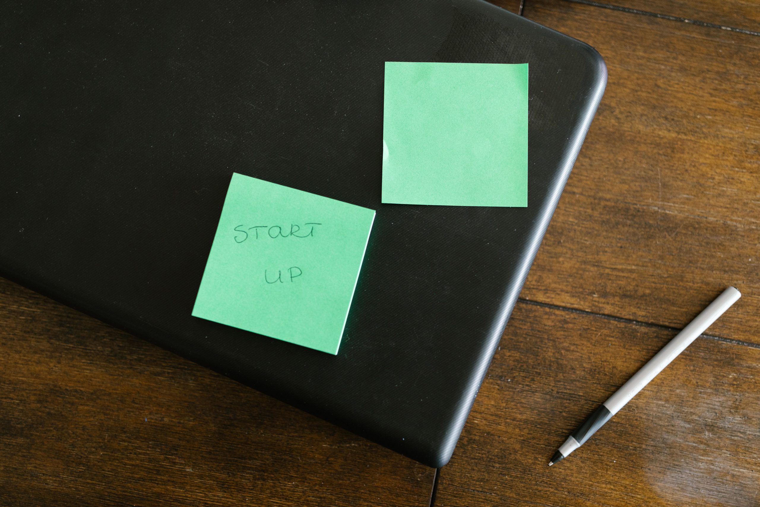 Ordinateur avec notes vertes pour planifier un projet