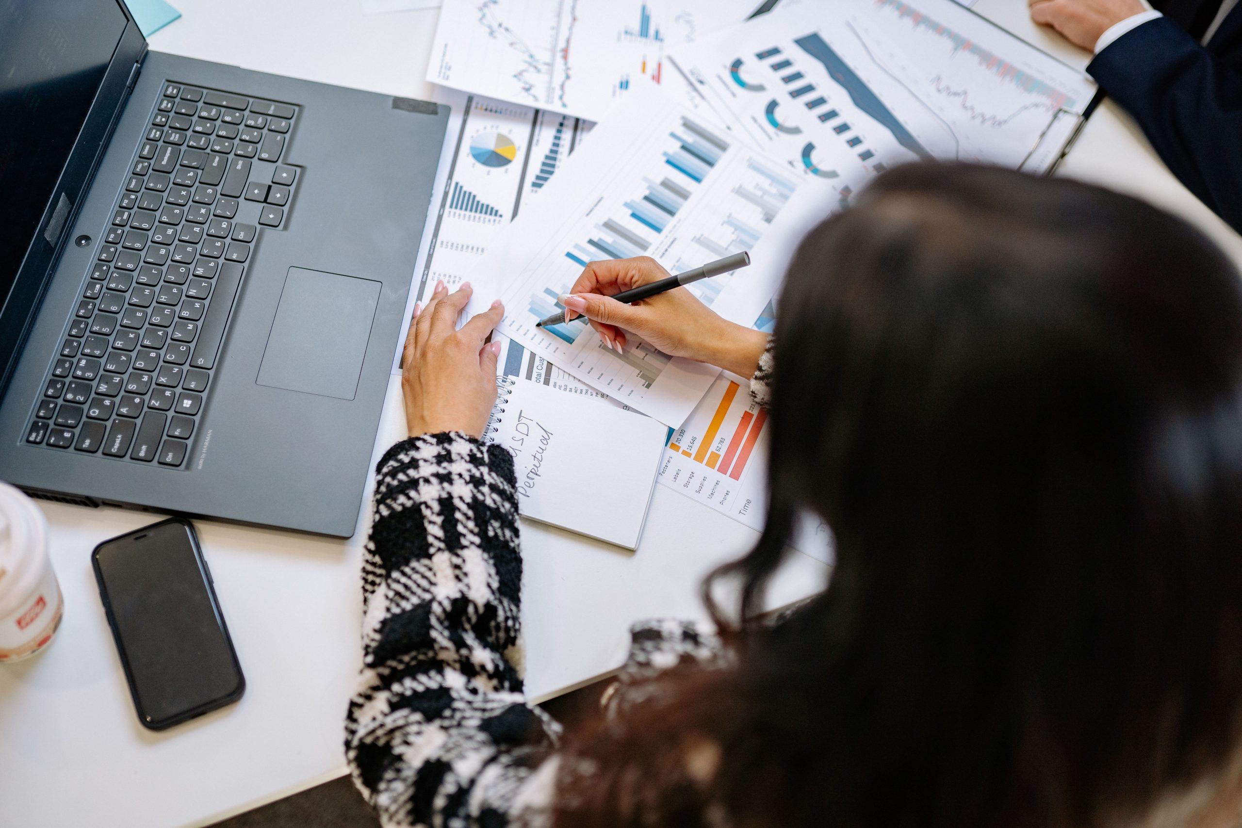 Femme professionnelle examinant des graphiques financiers sur ordinateur