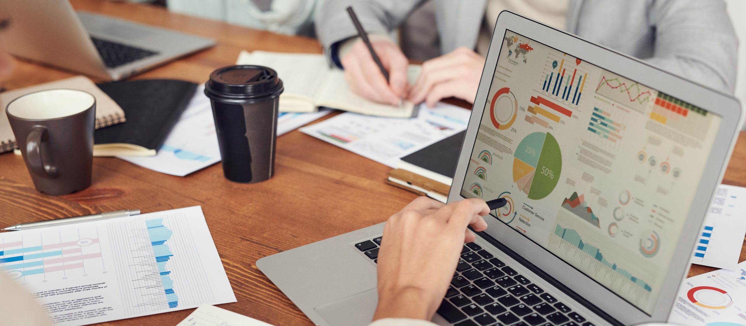 Professionnels en réunion analysant des données sur ordinateurs portables