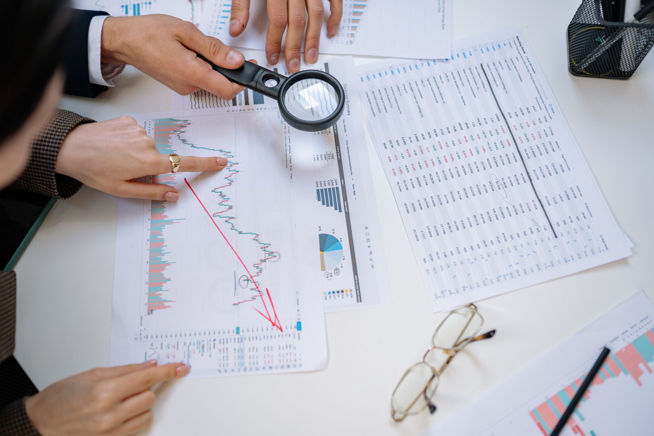 Professionnels examinant des documents financiers à la loupe