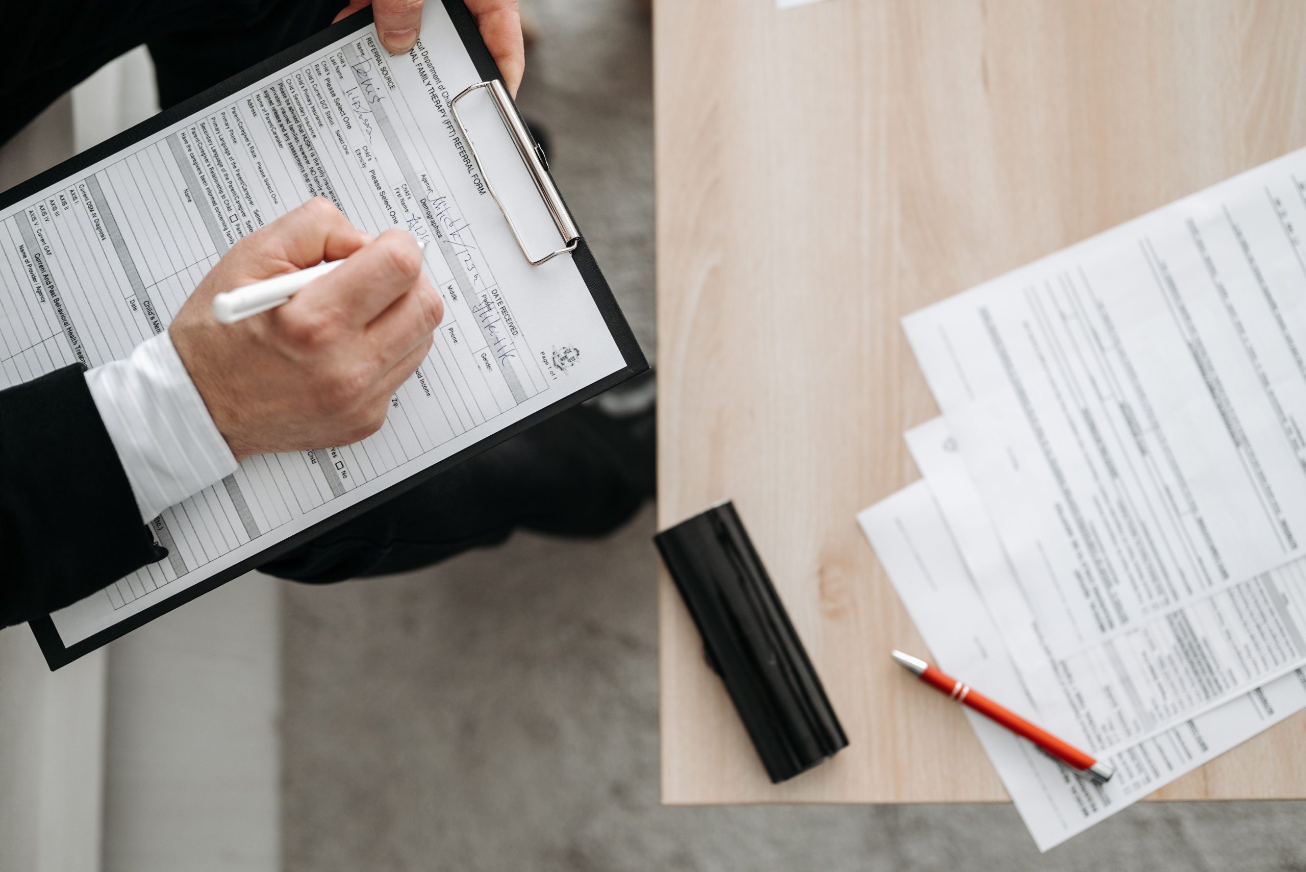 Personne remplissant des formulaires sur un presse-papiers