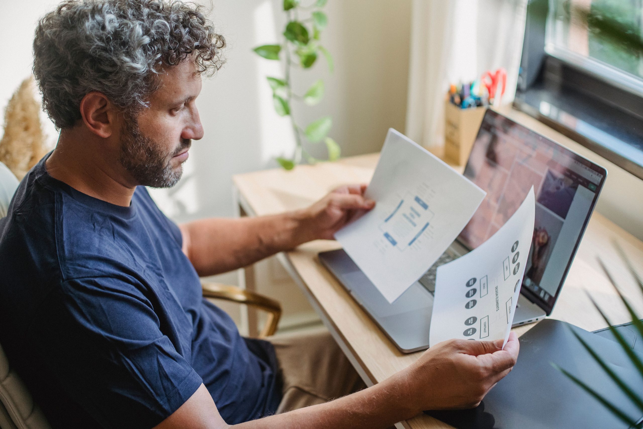 Homme travaillant avec des documents et son ordinateur portable