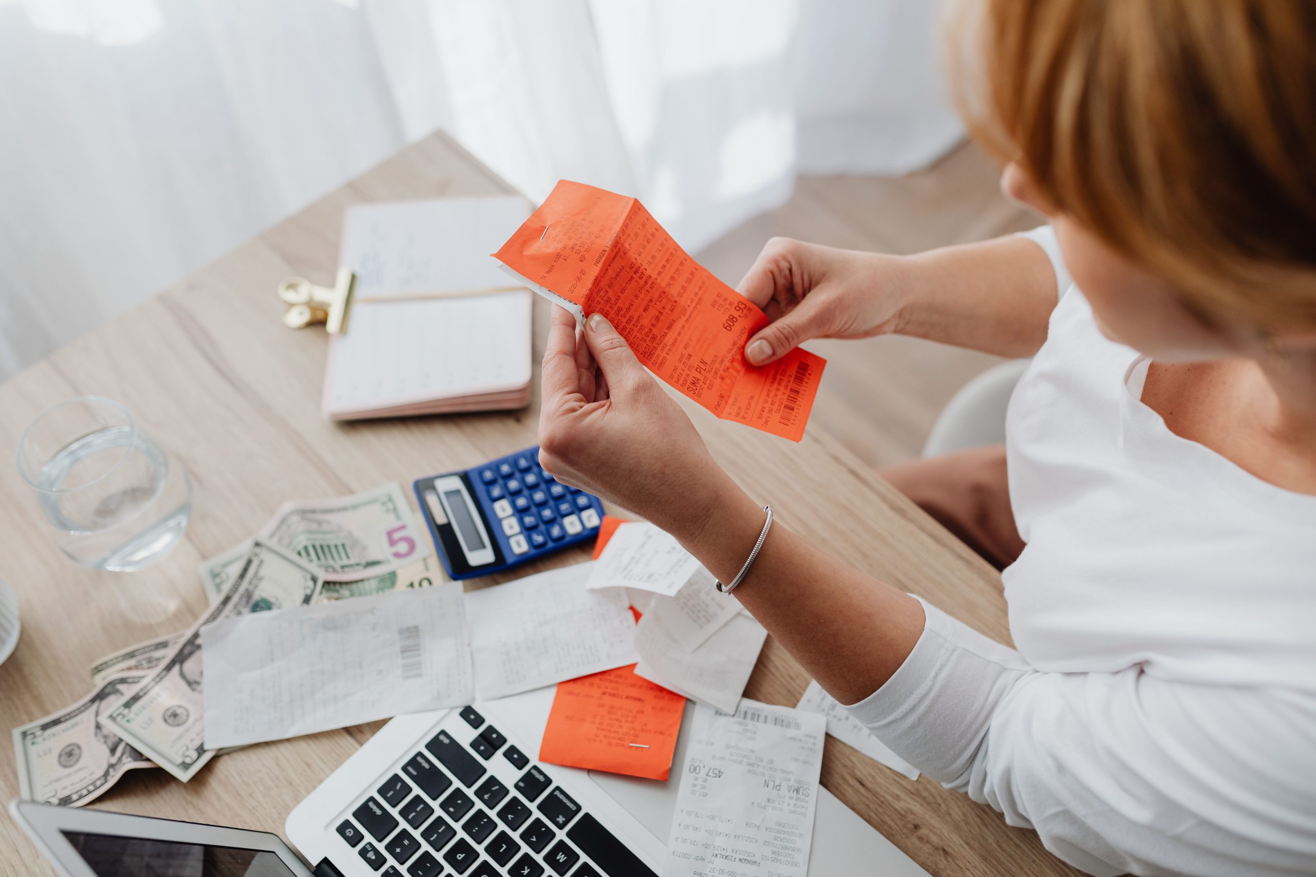 Femme utilisant une calculatrice et des factures