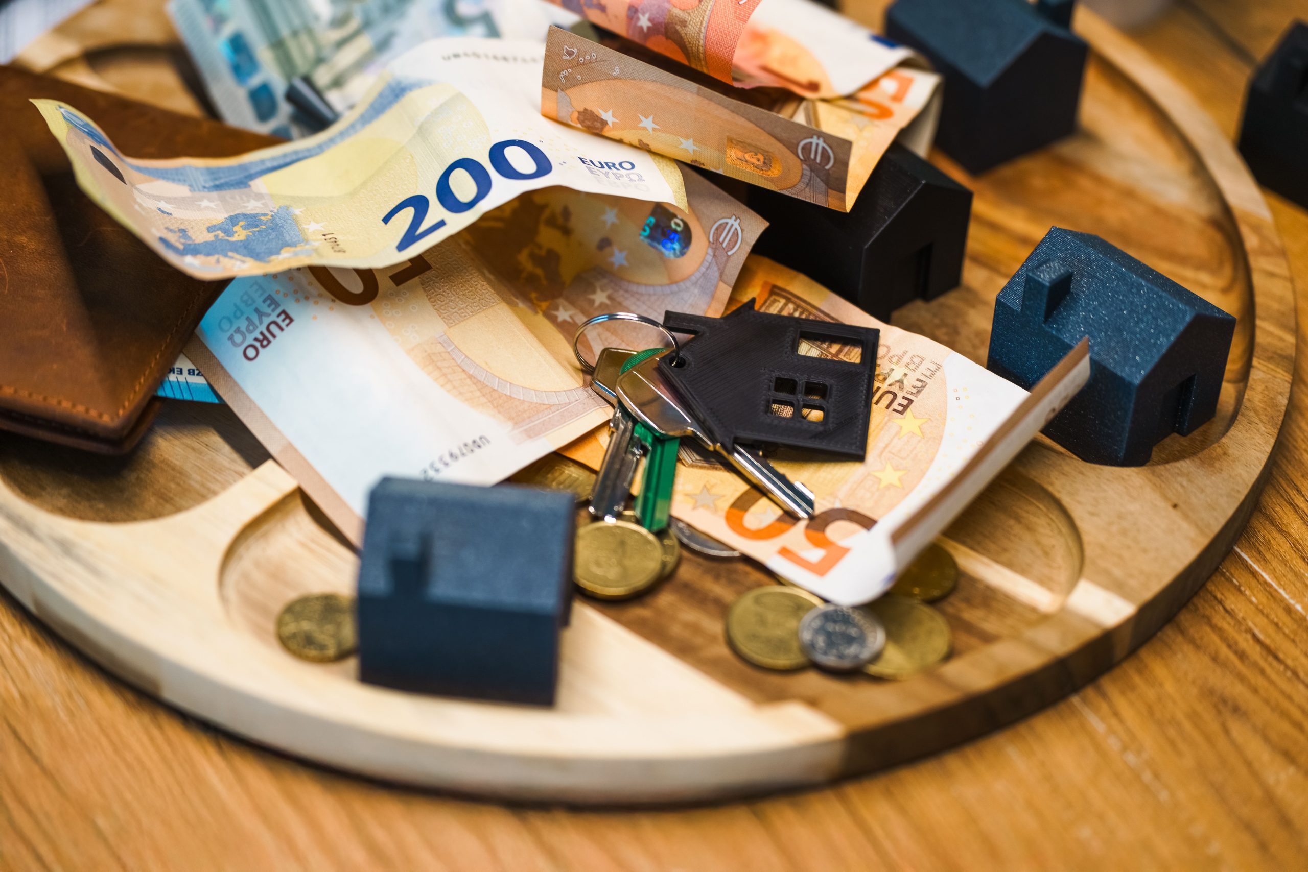 Billets en euros, clés et maisons miniatures