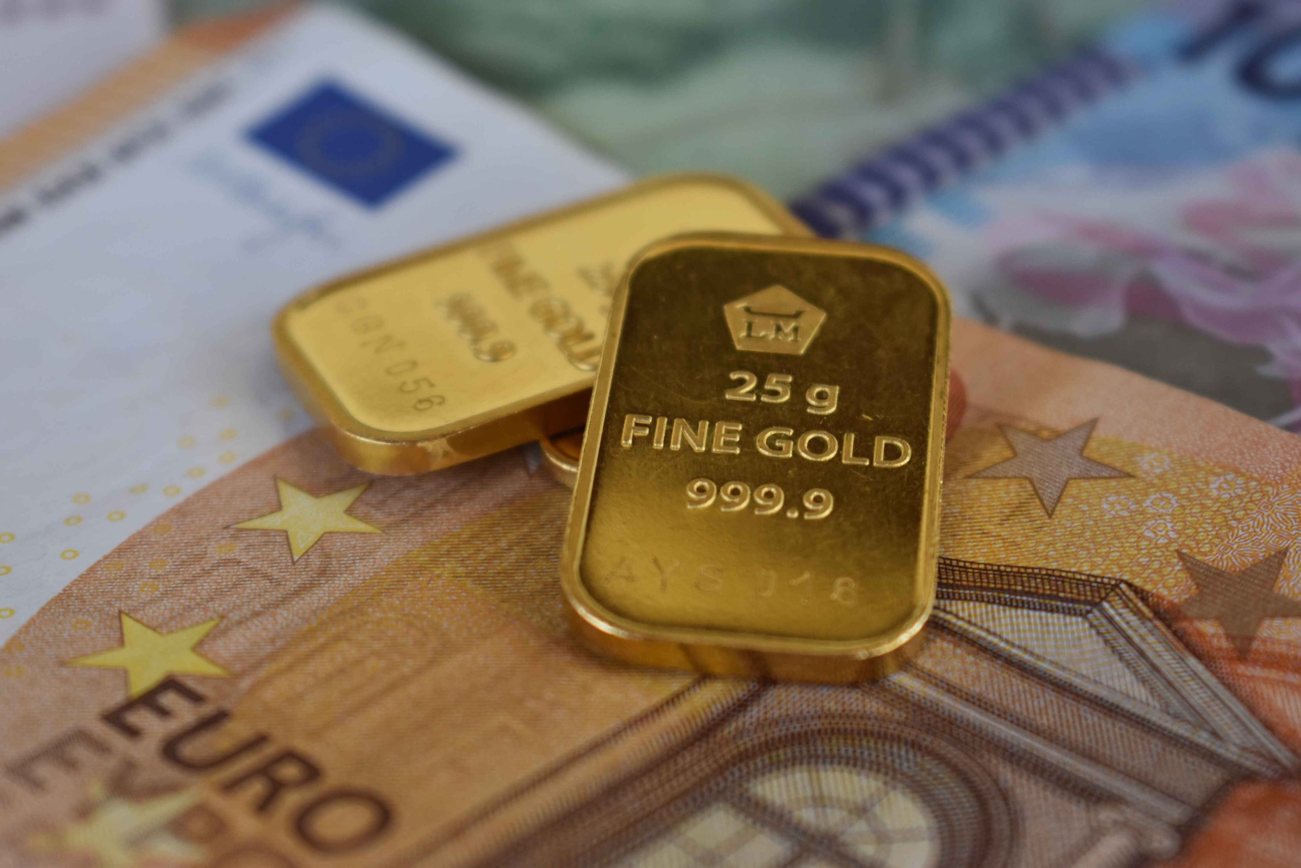 Lingots d'or posés sur des billets en euros représentant l'investissement.