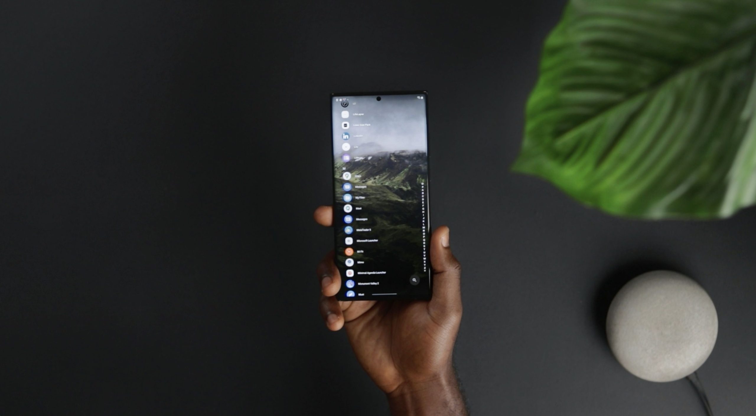 Main tenant un smartphone avec applications affichées