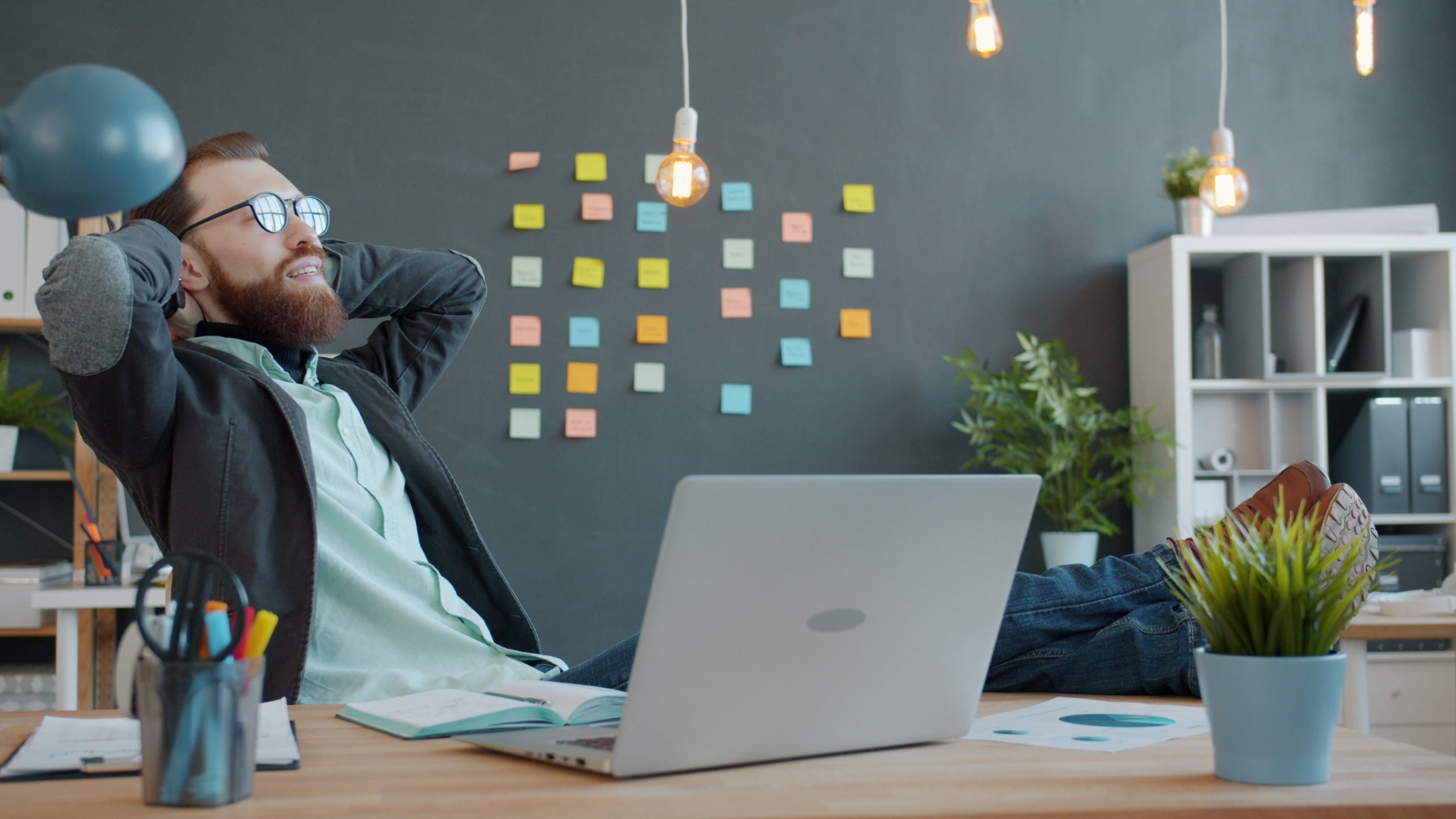 Jeune homme se relaxant en bureau moderne avec ordinateur
