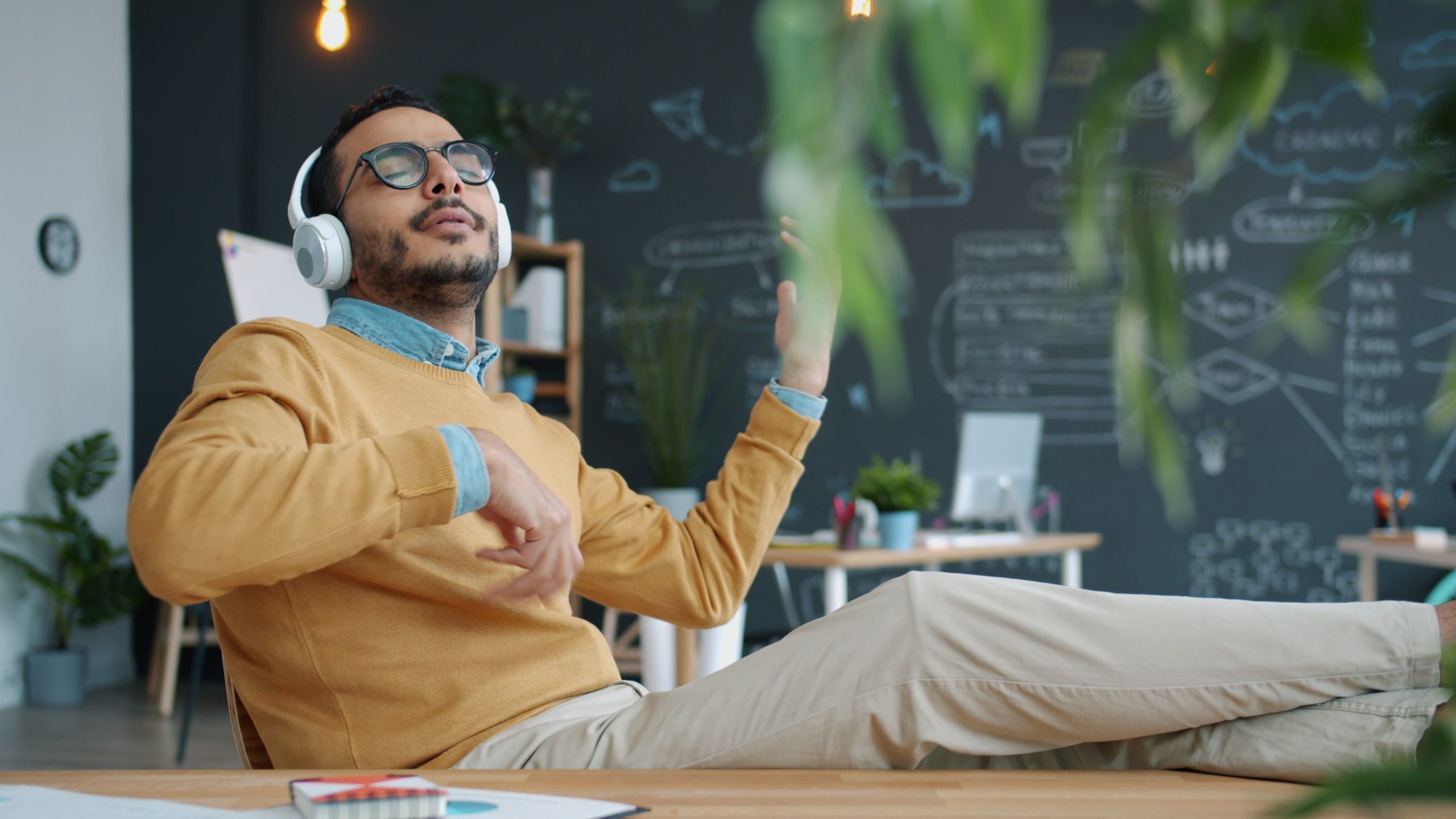 Homme se relaxant avec casque audio au bureau