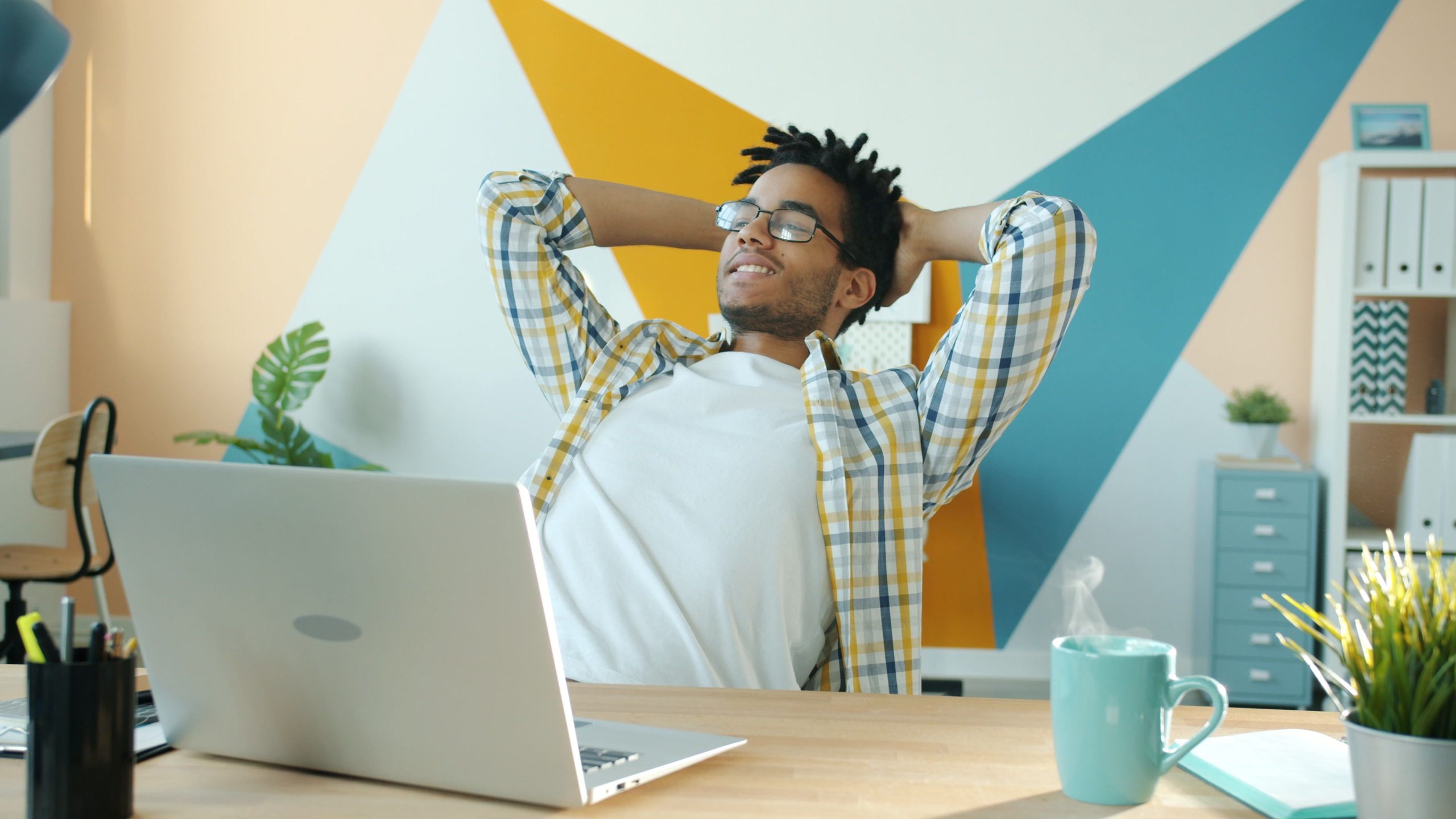 Jeune homme se détendant dans un bureau coloré avec café