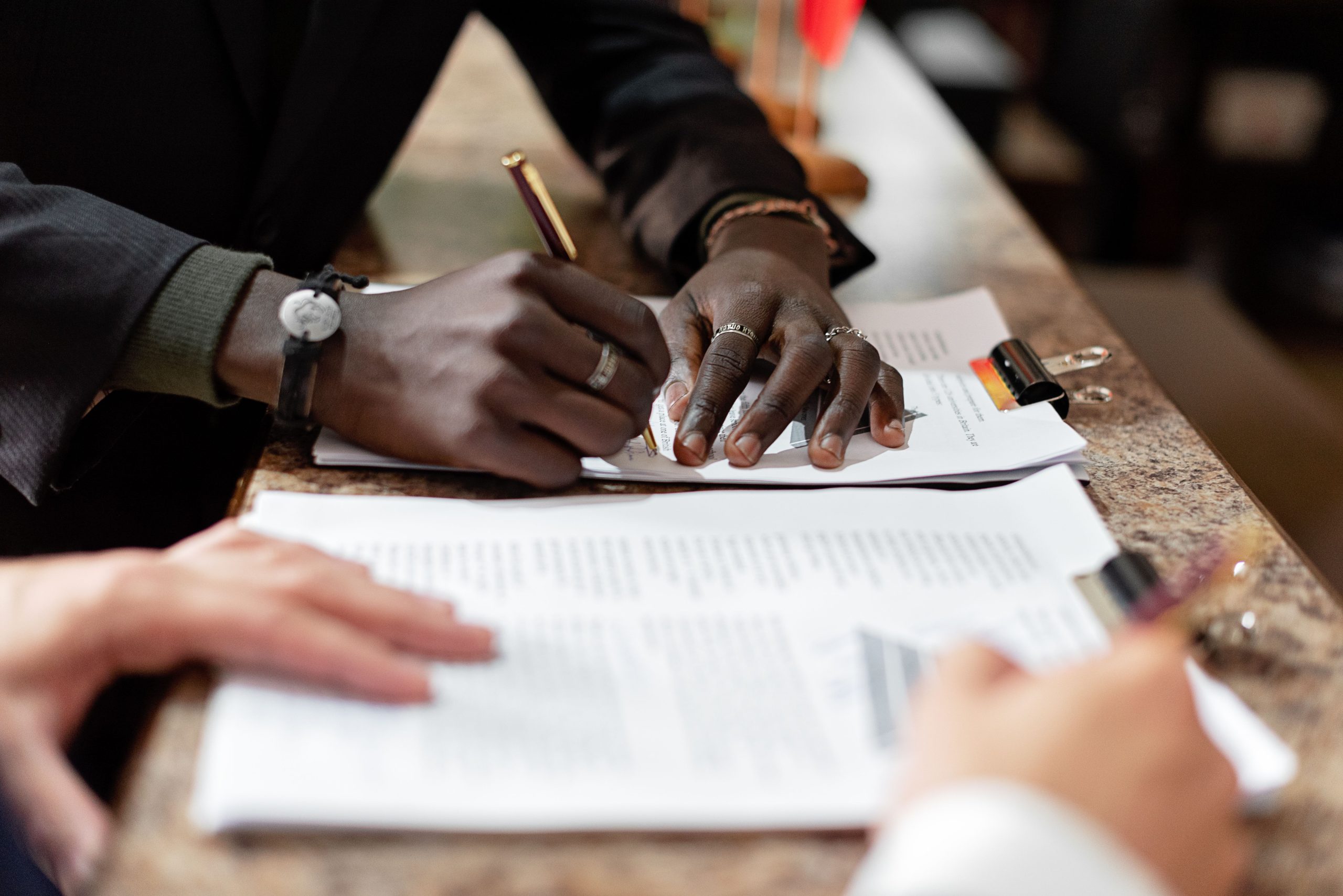 Mains signant des documents dans un environnement professionnel