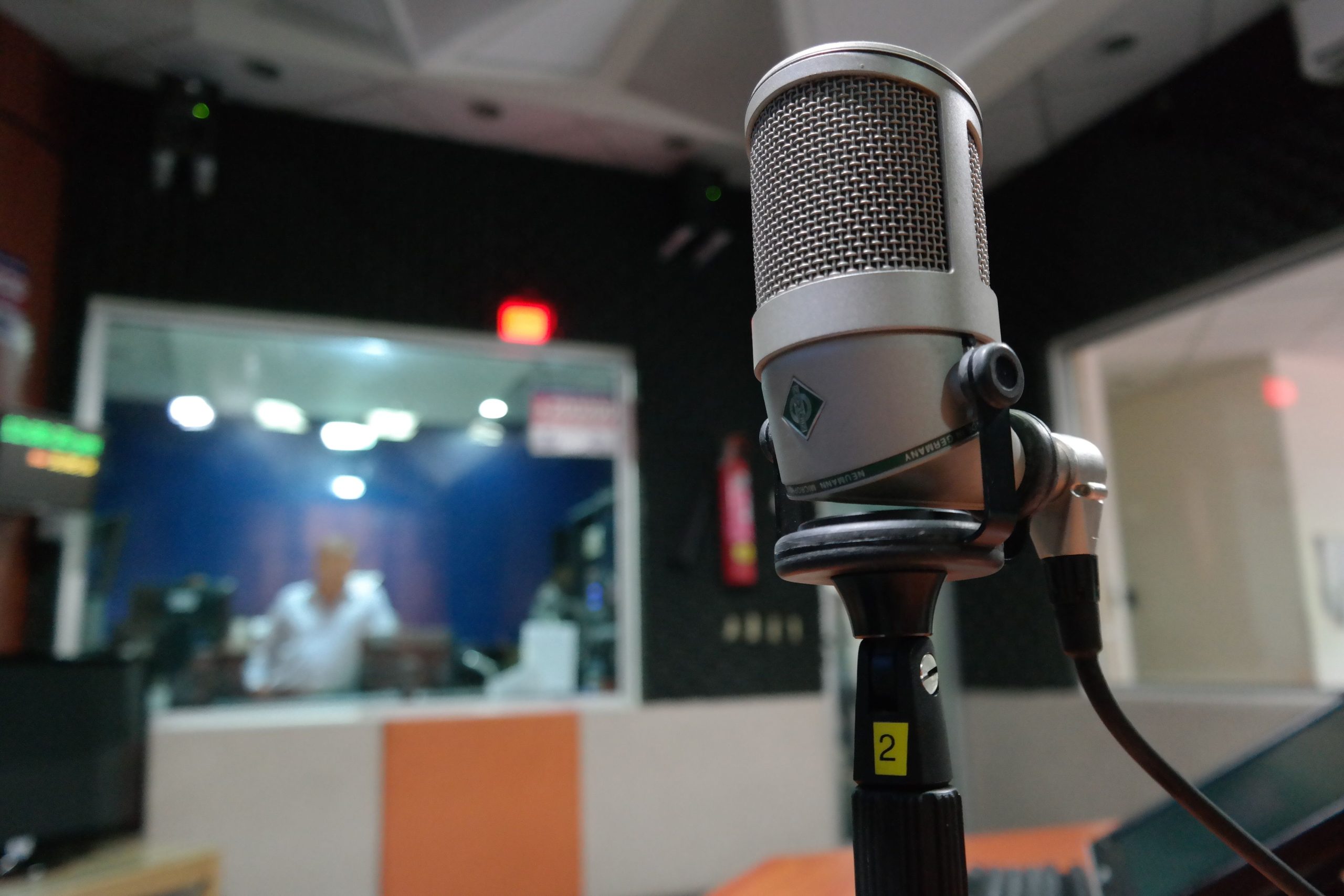 Microphone en studio avec ingénieur du son en arrière-plan