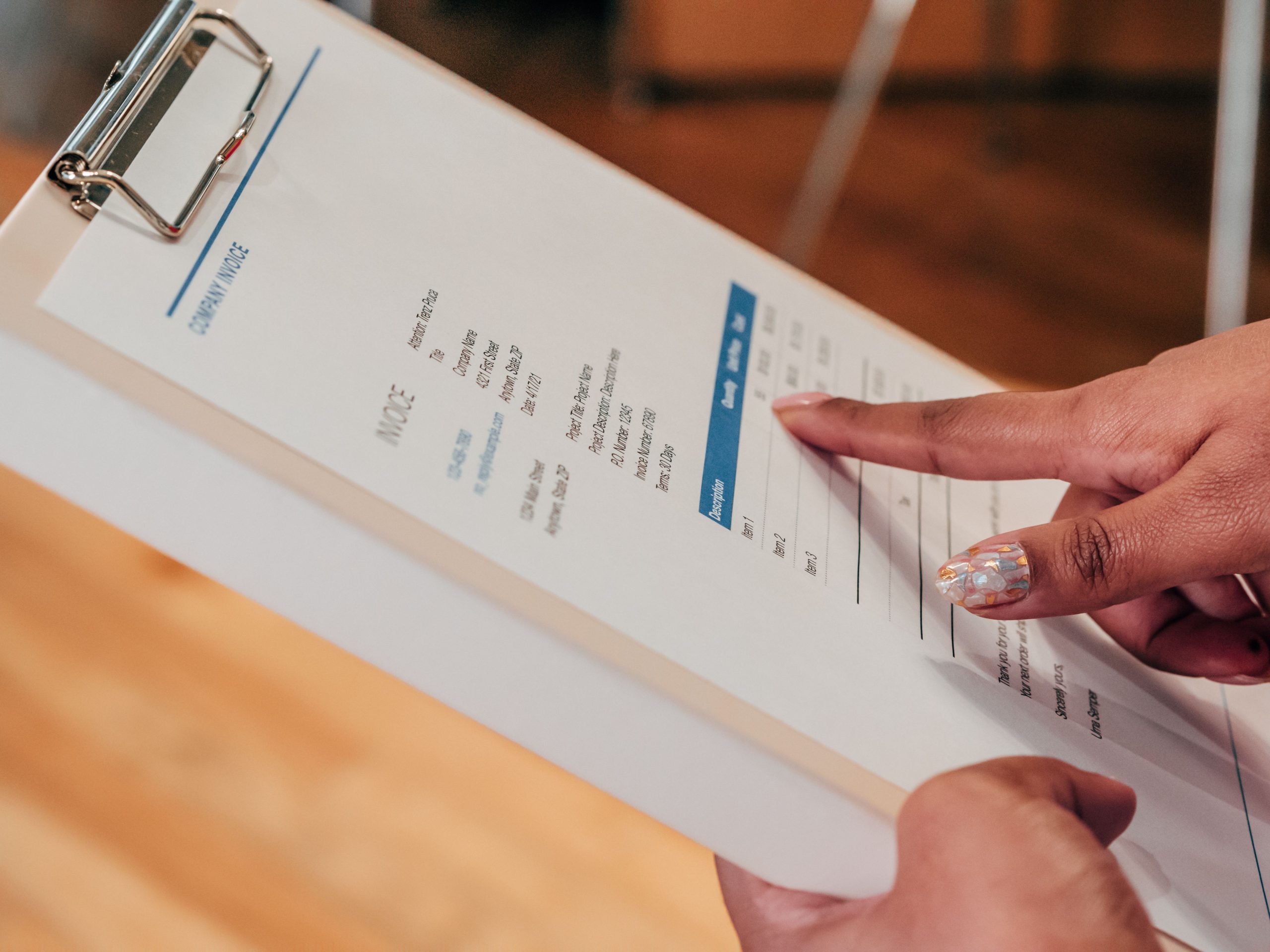 Personne pointant un document sur presse-papiers
